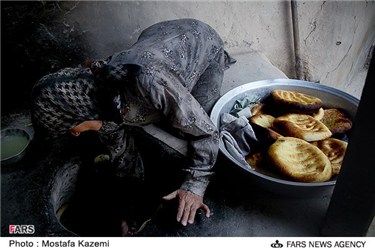 یک زن روستایی در حال پخت نان در روستای کوات است