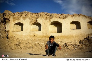 یک کودک در میان خانه های ویران شده کوات است