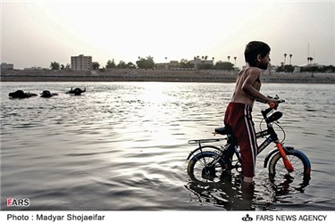 کودک دوچرخه سوار در ساحل رودخانه کارون