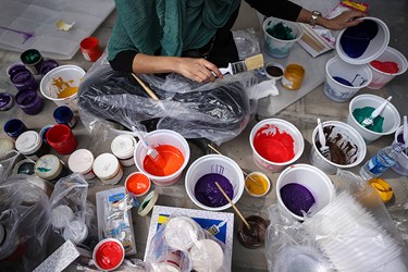 یکی از نقاشان در حال آماده کردن رنگ ها برای شروع به کار نقاشی بر روی تخم مرغ خود می باشد.