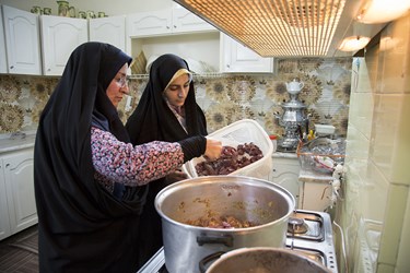 اعضای گروه جهادی فتح، معصومه پاپی نژاد و فائزه مسعودی در حال پخت غذا