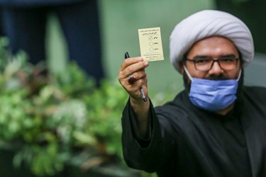 نمایش رای یکی از نمایندگان به عکاسان حاضر در مجلس شورای اسلامی 