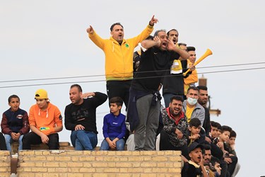 هواداران تیم فوتبال صنعت نفت آبادان بر روی پشت بام خانه های اطراف ورزشگاه به تماشا نشسته اند