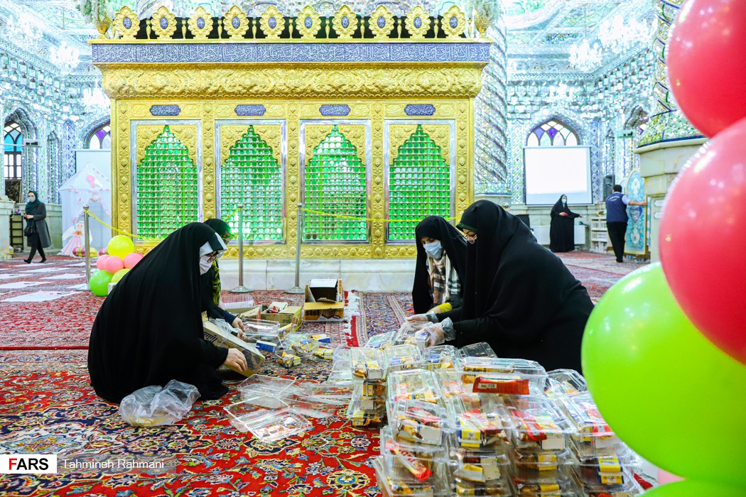 قبل از شروع مراسم جشن تکلیف، خادمان امامزاده در حال بسته بندی پک های میوه هستند.