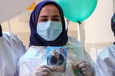 عکس مزین به سردار سلیمانی در دست یکی از پرسنل کادر درمان