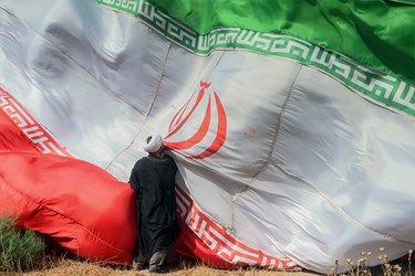 بوسه بر پرچم ایران توسط یکی از طلاب در مراسم 
