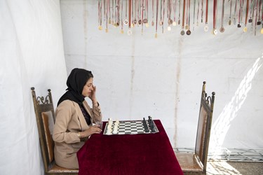 یکی از مددجویان سرای احسان که در رشته شطرنج مدالهای بسیاری کسب کرده است درغرفه خود نشسته است. 