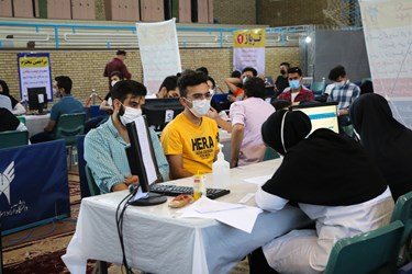 دانشجویان مشهدی در حال ثبت اطلاعات ثبت از تزریق واکسن کرونا هستند.