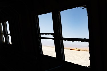 کشتی‌ به نمک نشسته در کف دریاچه ارومیه از پنجره کشتی دیگری در بندر شرفخانه در شمال‌شرق دریاچه ارومیه دیده می‌شود.