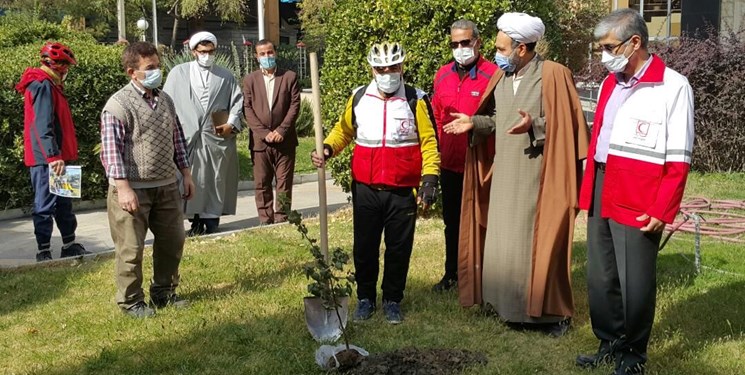 جهانگرد دوچرخه‌سوار در مشهد به یاد شهدای مدافع سلامت نهال کاشت