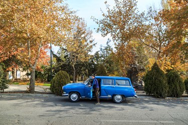 اکبر نمکی خامنه در حال نشستن در خودرو قدیمی روسی خود در محله چنار شهر خامنه است.