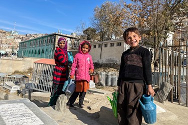 تعدادی از کودکان جهت شستشوی قبور در آرامستان سَخی شهر کابل افغانستان به کار مشغولند