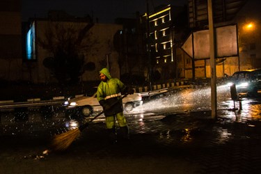 یکی از پاکبان ها  مشغول پاکسازی  معابرسطح شهر تهران  در محل شیفت خود است 
