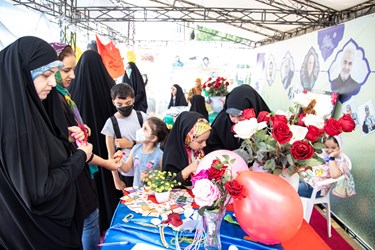 اهدا گل به افراد حاضر در غرفه عفاف و حجاب در نمایشگاه بین المللی کتاب