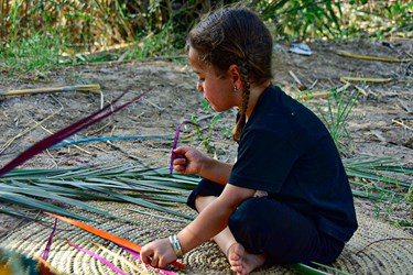کودک خانواده در کنار مادر و مادربزرگ برای ساخت صنایع دستی آموزش می بیند