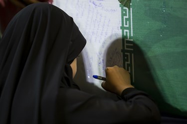 نوشتن نامه بر روی پیکر شهید گمنام در مراسم دعای عرفه  مصلی امام خمینی (ره)