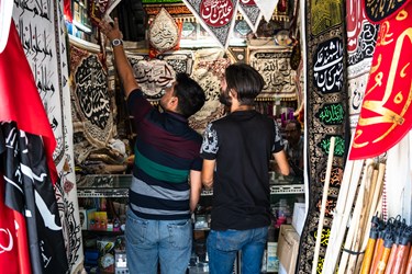 دو جوان در حال انتخاب پرچم برای هیئت هستند