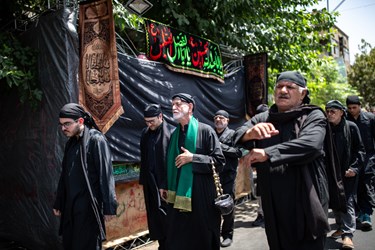 دسته سقا ها در حال نوحه خوانی به سمت امامزاده بازار بزرگ تهران میروند