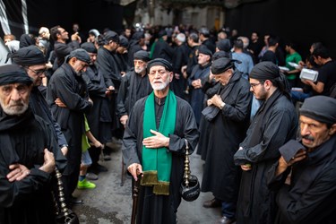 دسته سقا ها در حال نوحه خوانی به سمت امامزاده بازار بزرگ تهران میروند