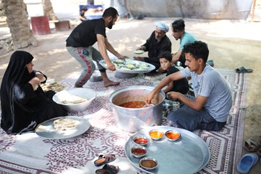 حسن به همراه همسر و فرزندان و اقوامش مشغول توزیع غذا هستند.