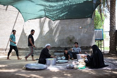 حسن به همراه همسر و فرزندان و اقوامش مشغول توزیع غذا هستند.