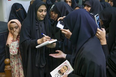 امضای کتاب توسط مادر شهید آرمان علی‌وردی
