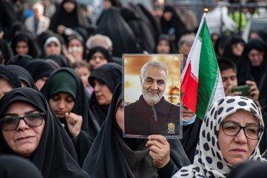 تصویر شهید حاج قاسم سلیمانی و پرچم ایران را  در مراسم سالگرد شهادت شهید علی وردی  