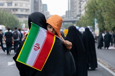 کودکی پرچم ایران را در راهپیمایی 13 آبان به دست دارد