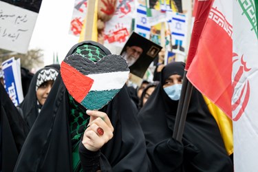 ماکت پرچم فلسطین در دستان یک دانش آموز در راهپیمایی 13 آبان