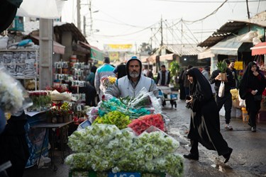 یک مرد، گاری پر از گل را در بازار گل محلاتی تهران در آستانه روز مادر حمل میکند،سه شنبه 12 دی 1402