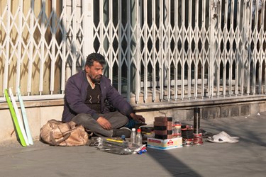 علی  غلامی پدر 4 فرزند در حال فروش لوازم جانبی کفش در خیابان انقلاب است.27 دی 1402
