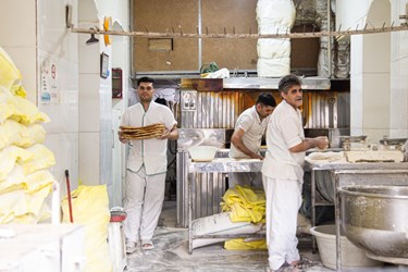 نانوایان مشغول پخت نان صبحگاهی  در خیابان انقلاب تهران هستند. 
3 بهمن 1402