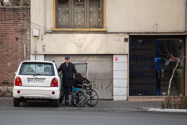 مردی در حال کمک کردن به مادر مسن خود در خیابان حافظ تهران است. 
25 دی 1402