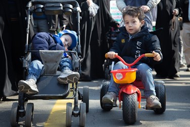 كودك خردسالي كه با دوچرخه خود در 45مین جشن انقلاب شرکت کرده است.