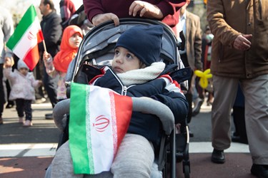 کودک خردسالی که به همراه پدر خود در جشن 45 سالگی انقلاب شرکت کرده است.