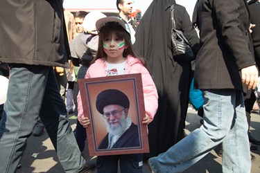 دختر خردسالی که با در دست گرفتن پوستر رهبری با آرمان های امام و رهبری تجدید میثاق میکند.