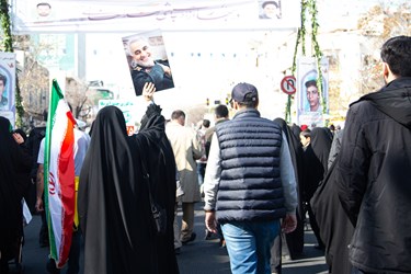 بانوی ایرانی پوستر حاج قاسم سلیمانی  را در جشن 45 سالگی انقلاب بدست گرفته است