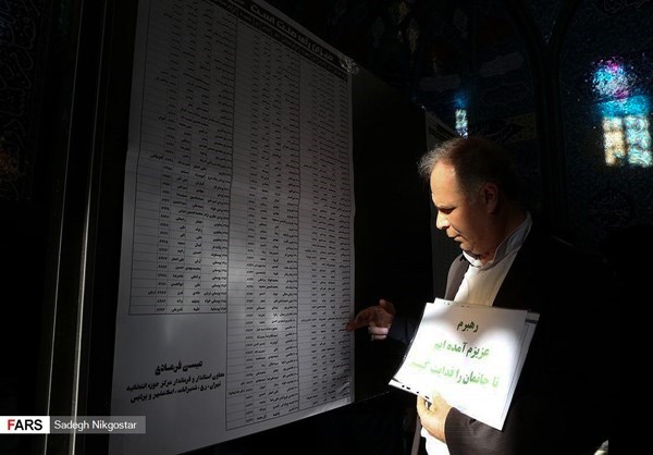 A man reviewed an election board in Tehran before casting his vote