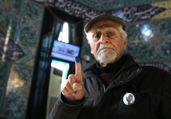 A man poses for a picture before verifying his identity with a fingerprint 